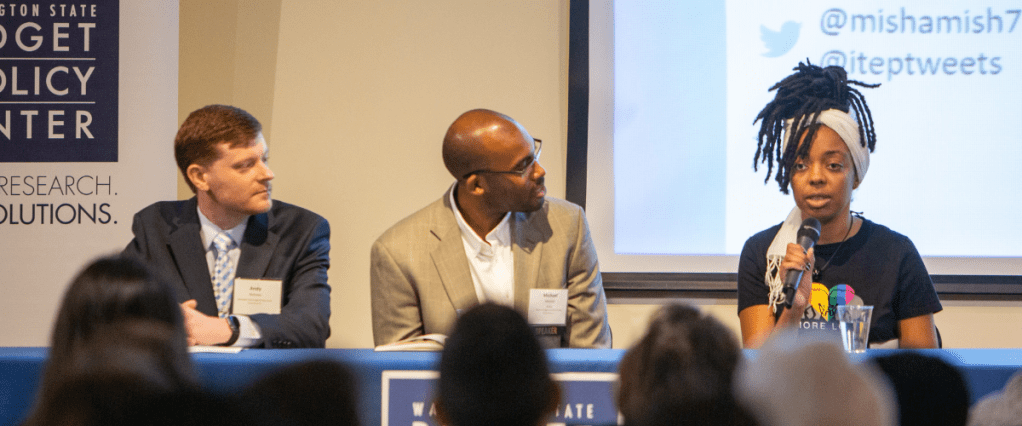 Three panelists sitting behind table